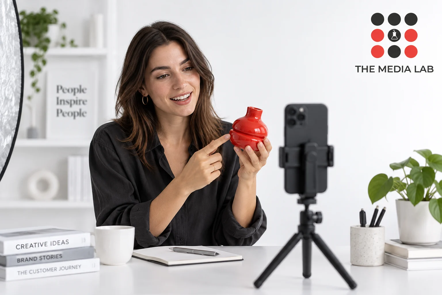 Creator demonstrating a red vase to a smartphone for The Media Lab’s influencer marketing guide.