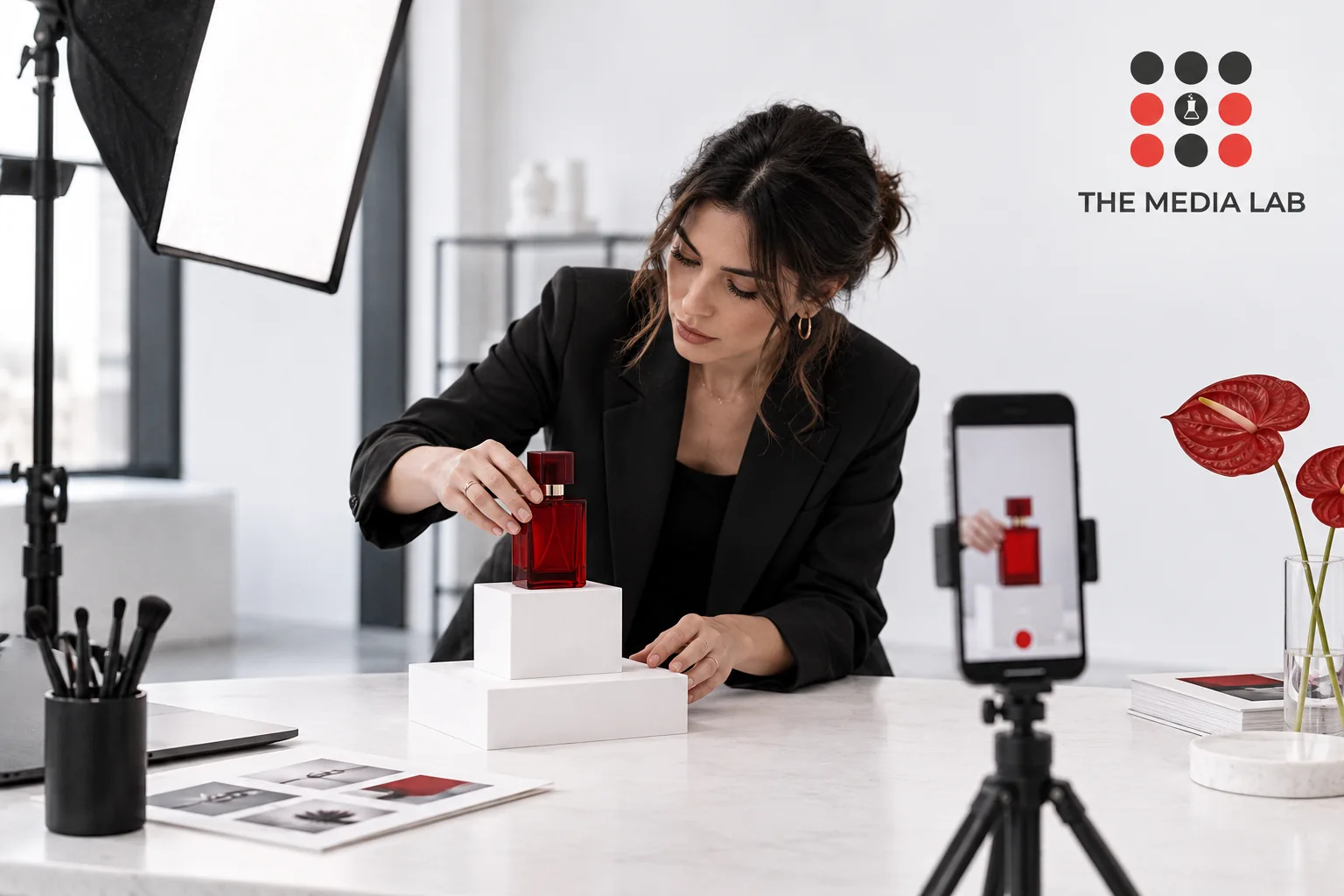 Director preparing a red perfume bottle for a mobile content shoot — editorial illustration for The Media Lab.