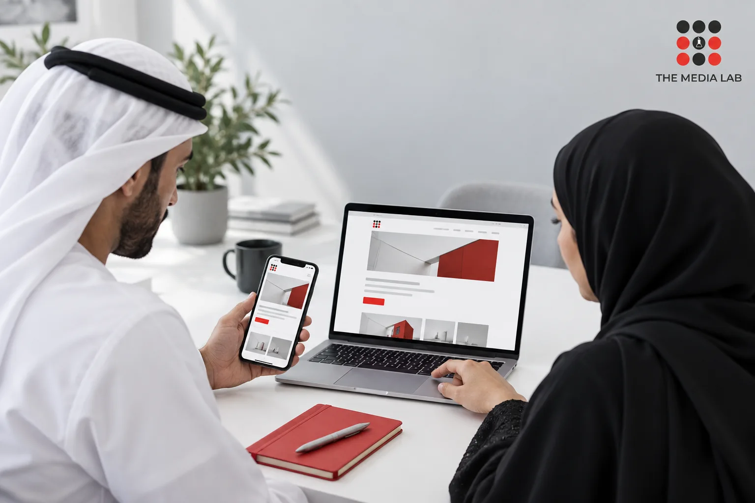Colleagues comparing a website on a phone and laptop, illustrating The Media Lab’s UAE digital connectivity guide.