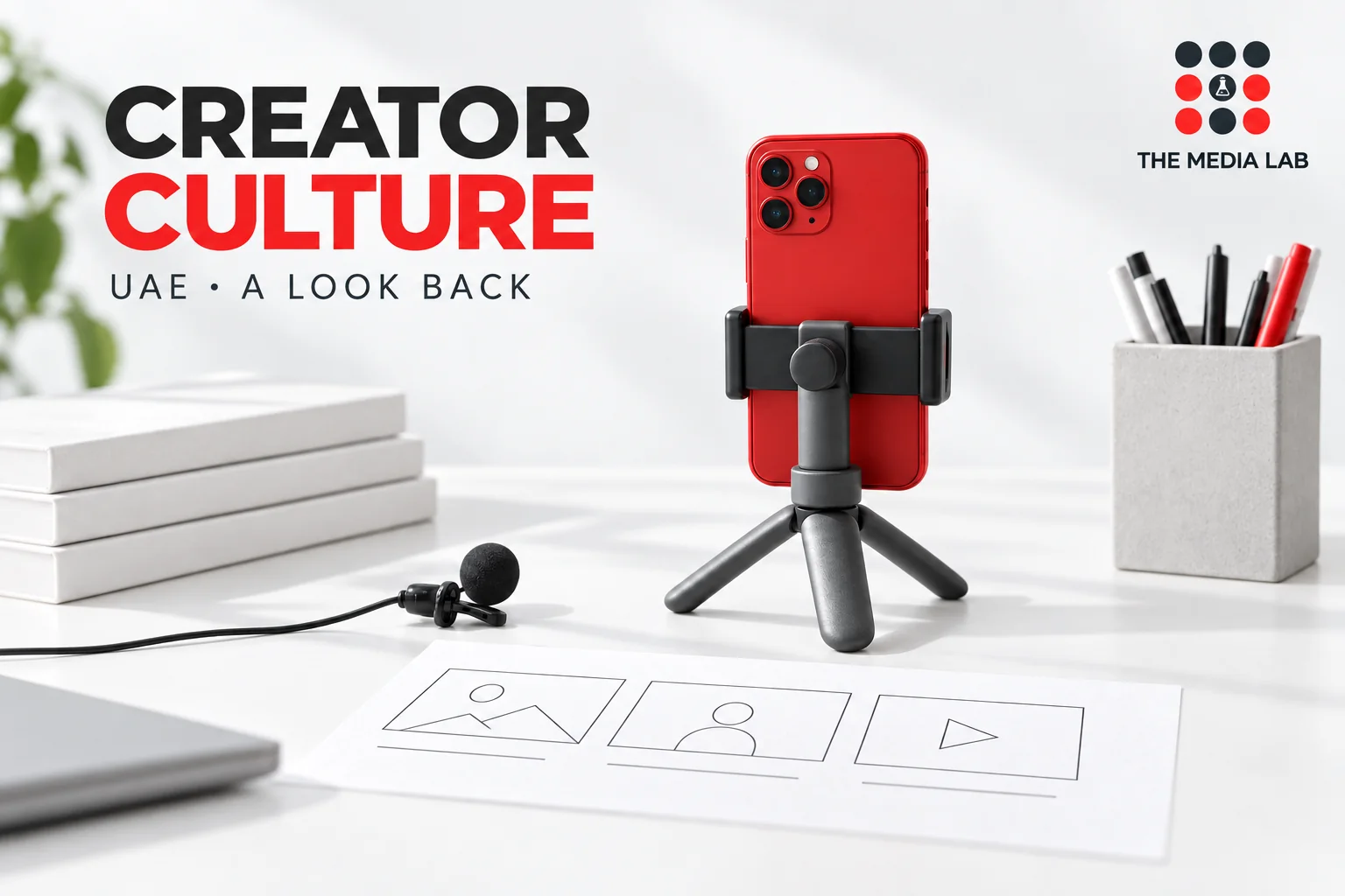 Red smartphone and storyboard on a studio desk for The Media Lab’s UAE TikTok influencer retrospective.