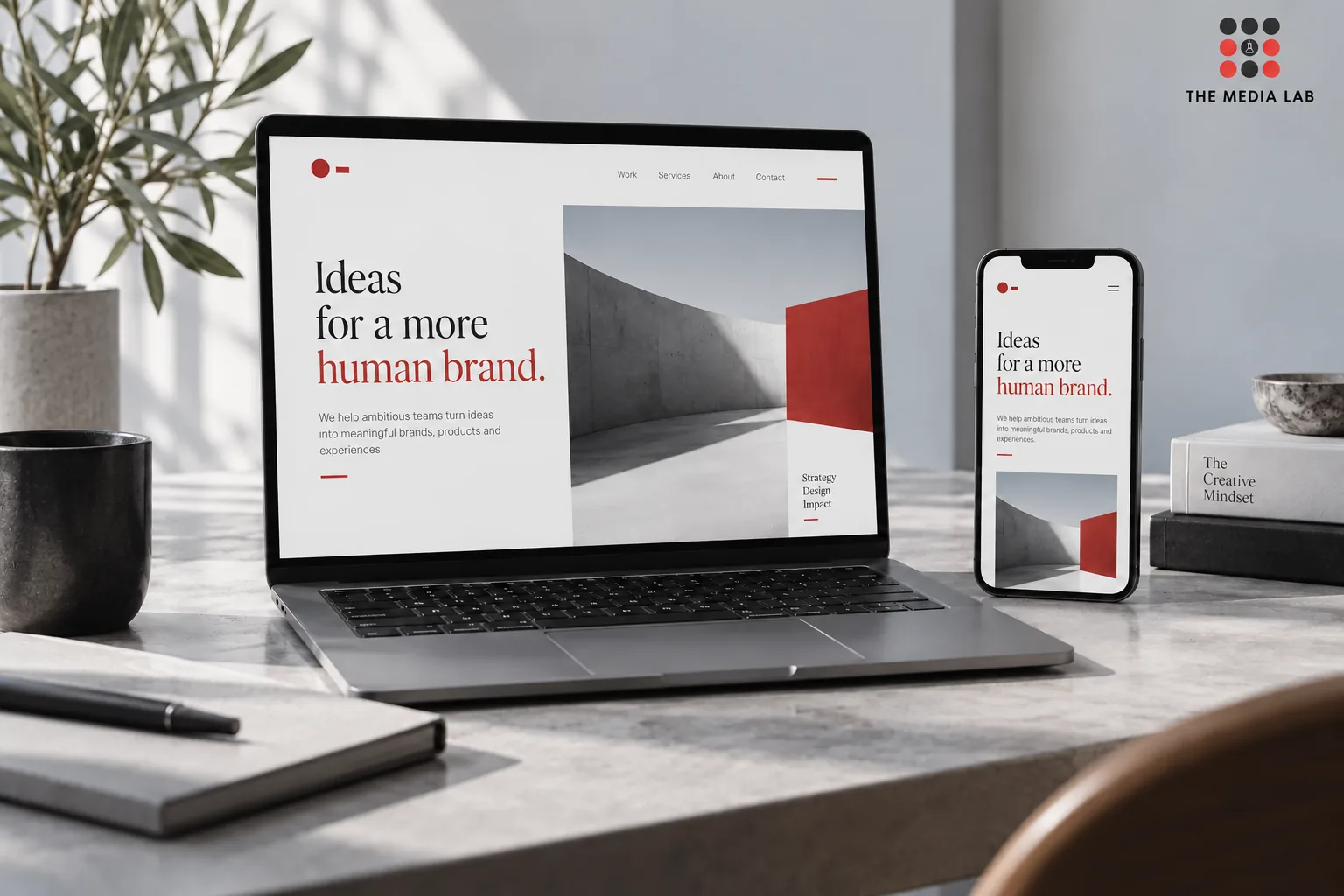 Responsive business website displayed on a laptop and phone — The Media Lab concept image.