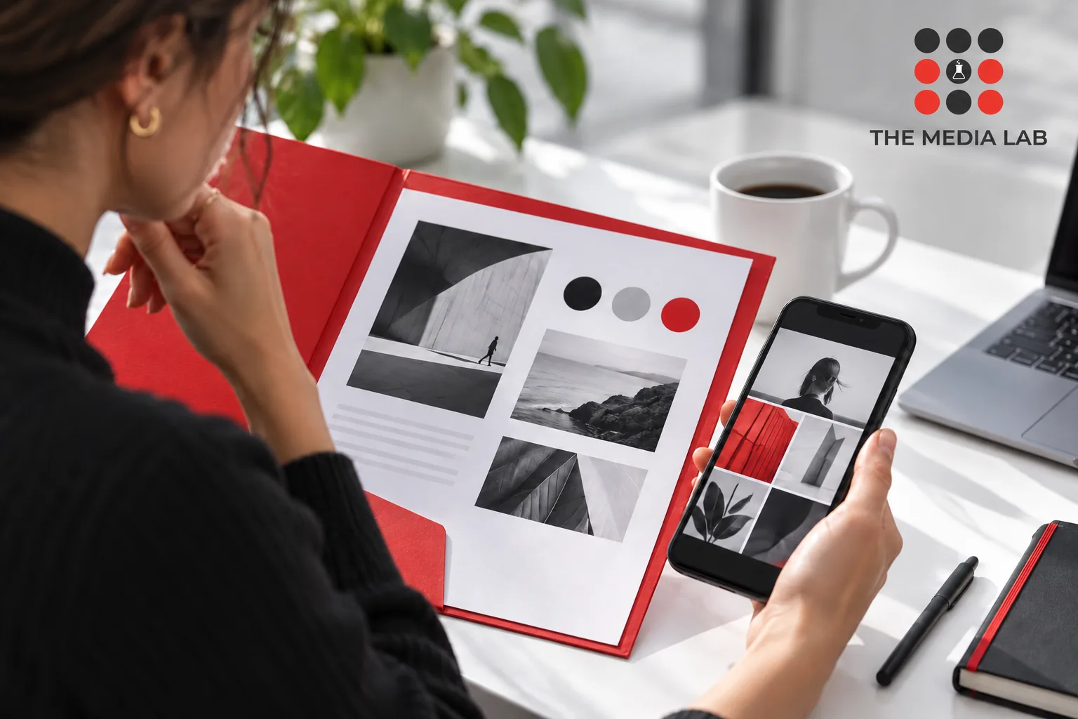 Creator reviewing a brand brief and phone portfolio, red folder white table — The Media Lab