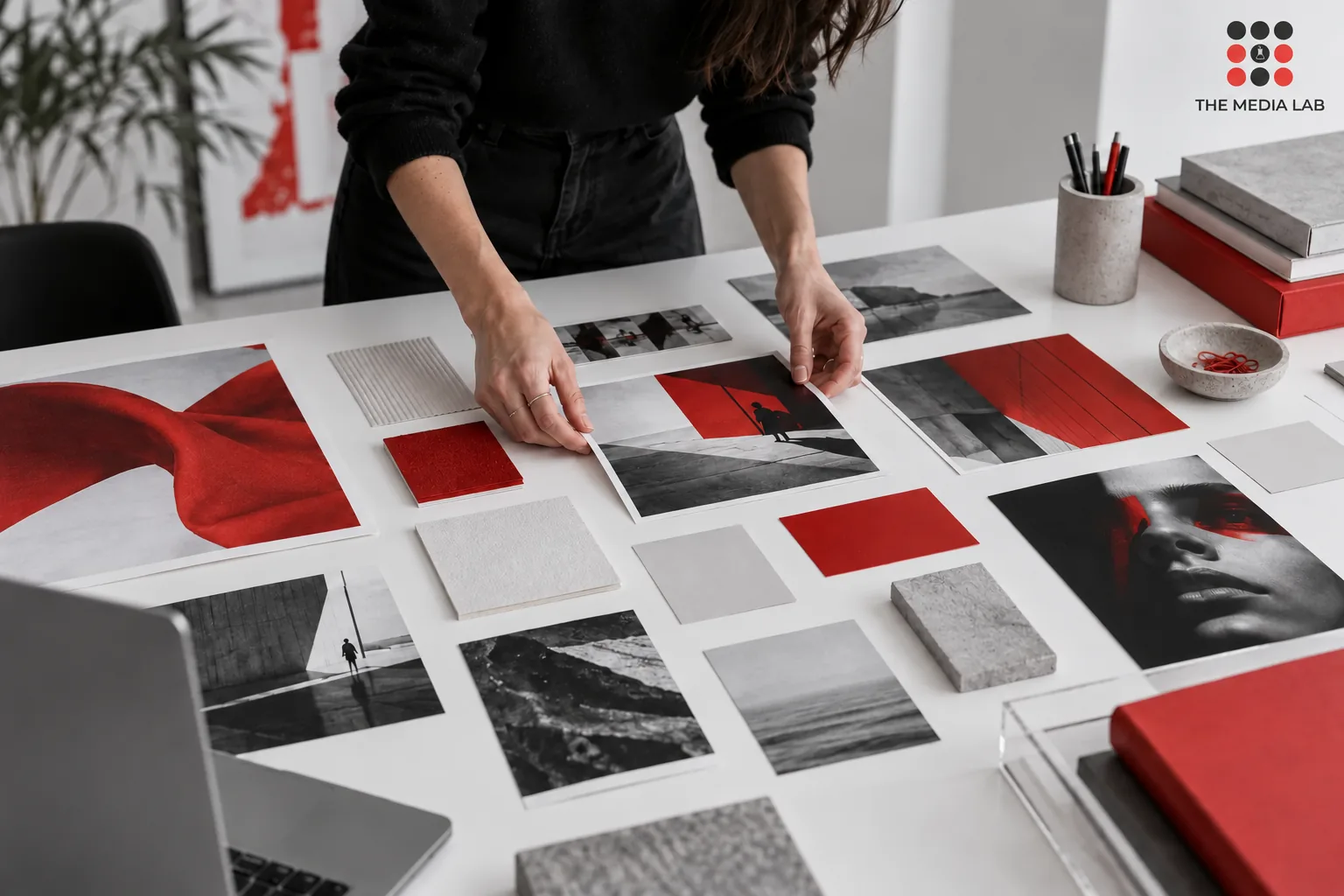 Designer arranging a red, white and grey visual identity moodboard — The Media Lab